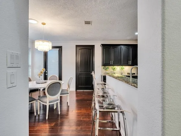 a kitchen with stainless steel appliances kitchen island granite countertop a table and chairs in it