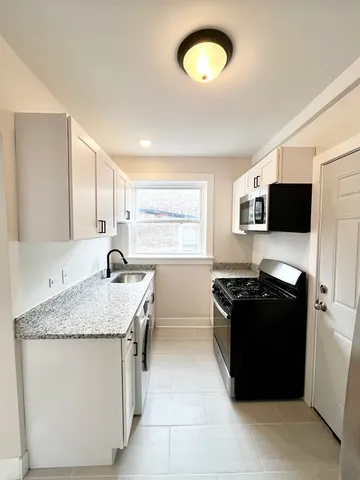 a kitchen with stainless steel appliances granite countertop a sink stove and microwave
