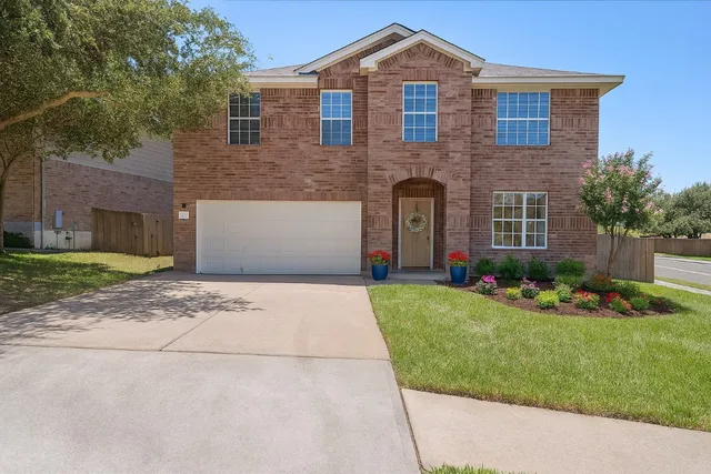 a front view of a house with a garden and yard