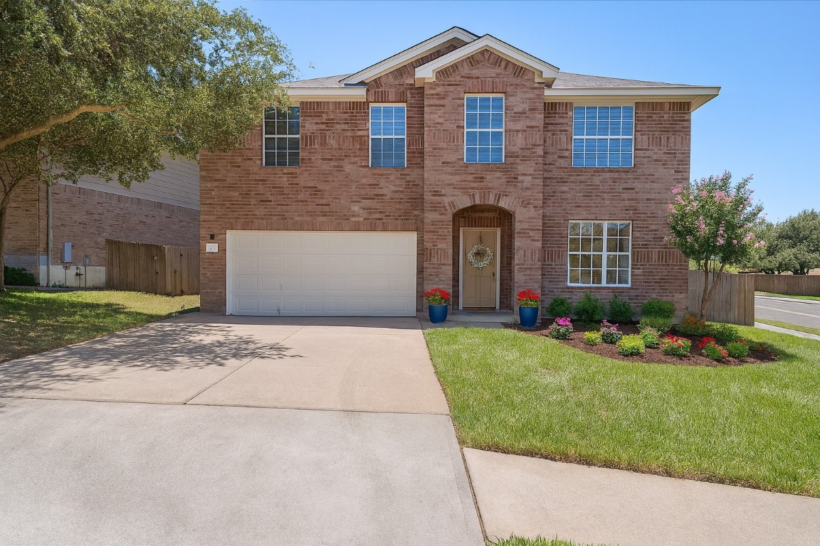 a front view of a house with a garden and yard