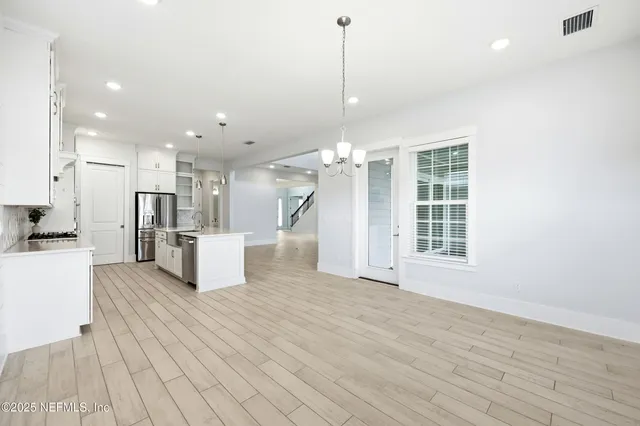 a view of an empty room with wooden floor