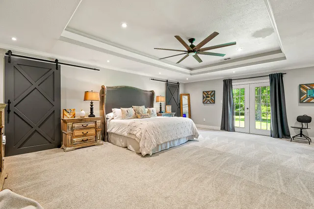 a spacious bedroom with a large bed and a chandelier