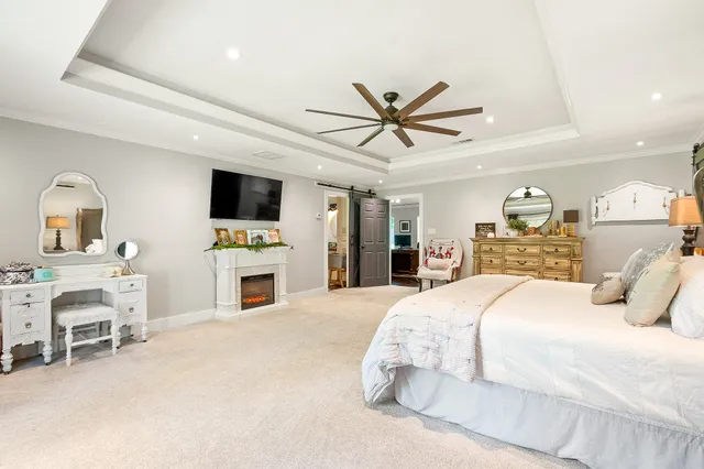 a bedroom with a bed a fireplace and a flat tv screen