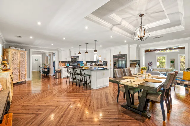 a dining room with stainless steel appliances lots of wooden furniture