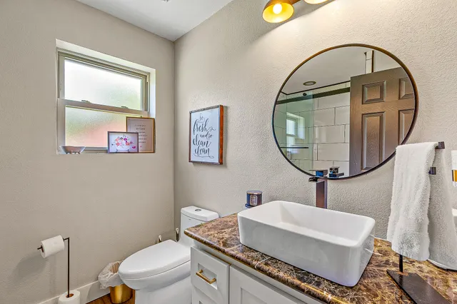 a bathroom with a toilet a sink and a mirror