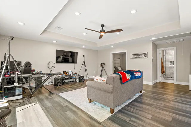 a living room with furniture kitchen view and a wooden floor