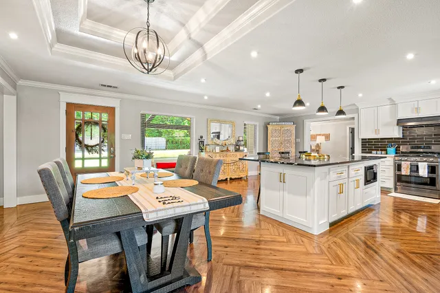 a living room with stainless steel appliances kitchen island granite countertop furniture and a wooden floor
