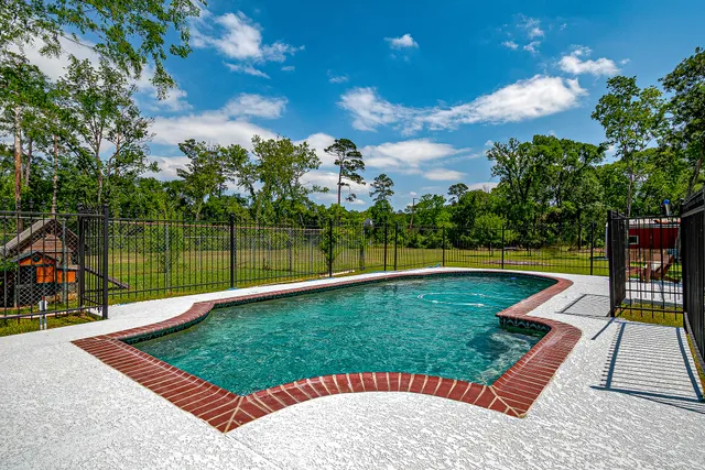 a view of a swimming pool with a yard and sitting area