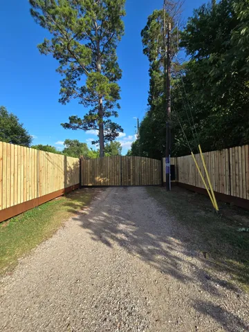 a view of a backyard with wooden fence