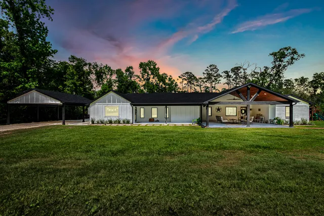 a view of a house with a yard and potted plants