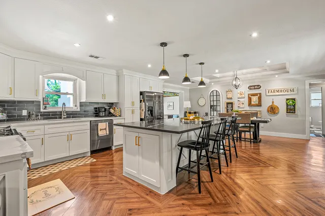 a kitchen with stainless steel appliances a table and chairs in it