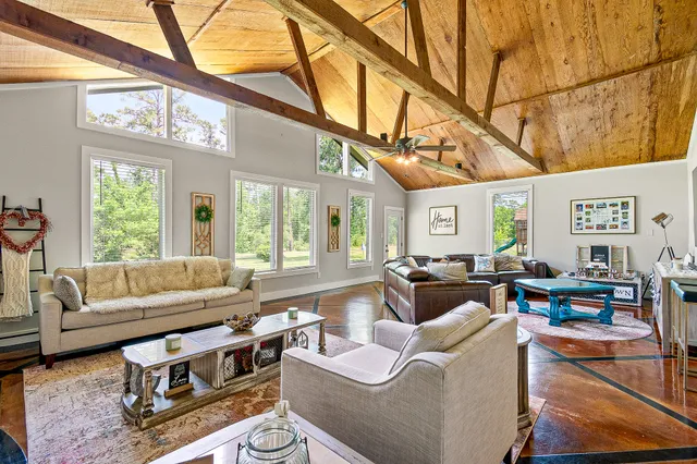 a living room with furniture a fireplace and a large window