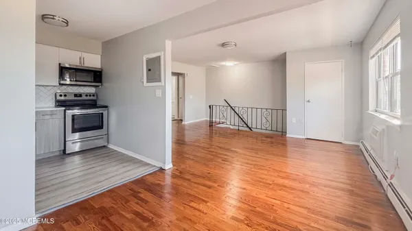 an empty room with wooden floor and electronic appliances