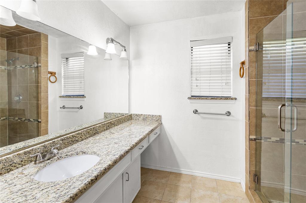 2421 Maple Leaf Drive Plano, TX 75075 - Photo 11 of 18 a bathroom with a granite countertop sink and a mirror