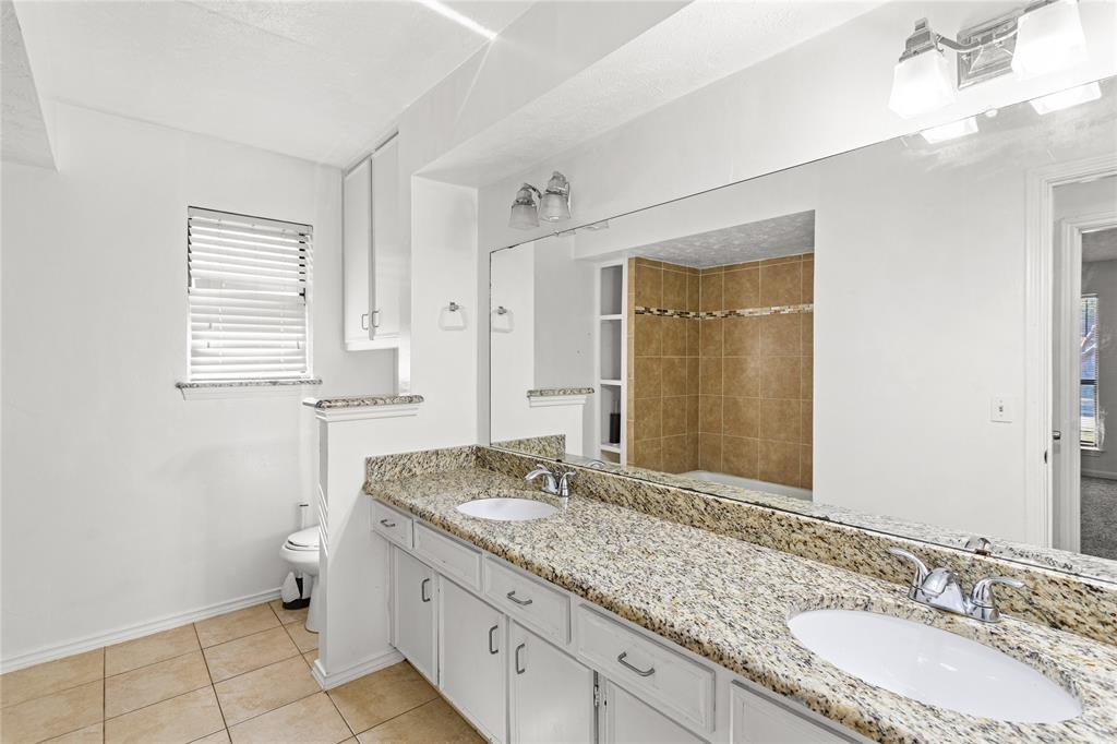 2421 Maple Leaf Drive Plano, TX 75075 - Photo 16 of 18 a bathroom with a granite countertop sink a toilet and a mirror