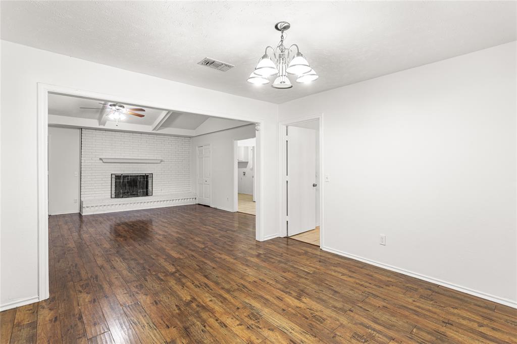 2421 Maple Leaf Drive Plano, TX 75075 - Photo 4 of 18 a view of an empty room with wooden floor and chandelier