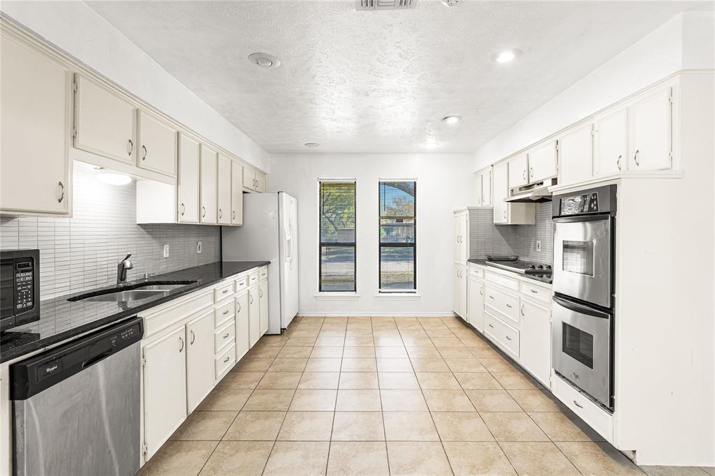 2421 Maple Leaf Drive Plano, TX 75075 - Photo 7 of 18 a large kitchen with cabinets a counter top space a sink stainless steel appliances and cabinets