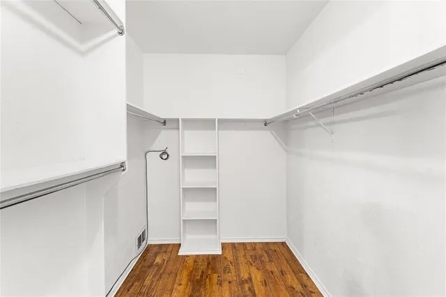 a view of a room with wooden floor and a window