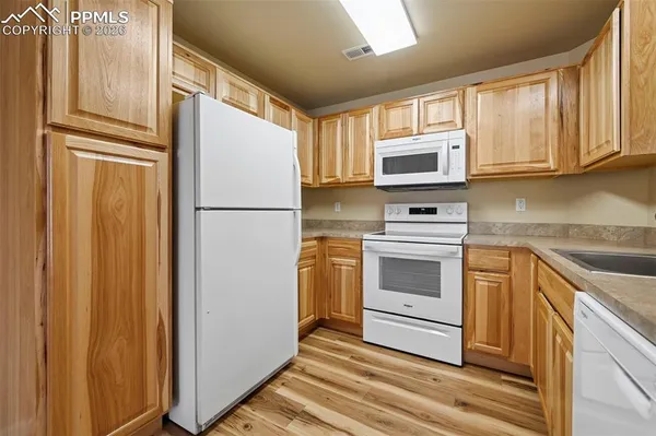 a kitchen with granite countertop a refrigerator stove and microwave