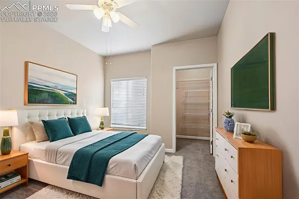 a bedroom with a large bed and a flat tv screen on dresser