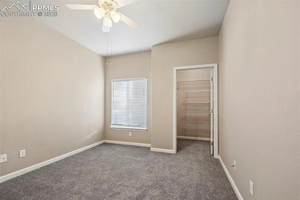 an empty room with fan and windows