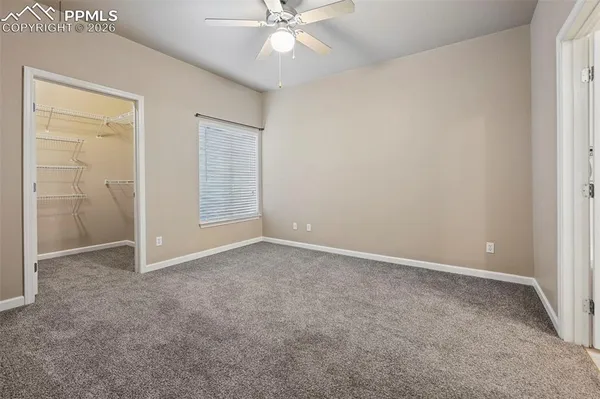 an empty room with closet and fan