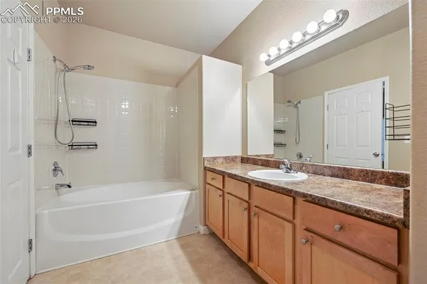 a bathroom with a granite countertop sink a mirror a shower and a bathtub