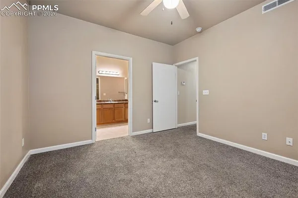 an empty room with fan and entrance