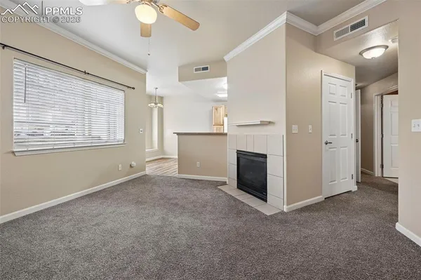 an empty room with windows and fireplace