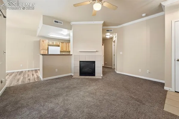 an empty room with windows and fireplace