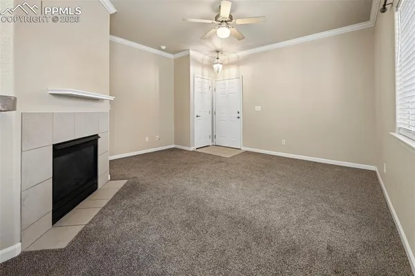 an empty room with fan and fireplace