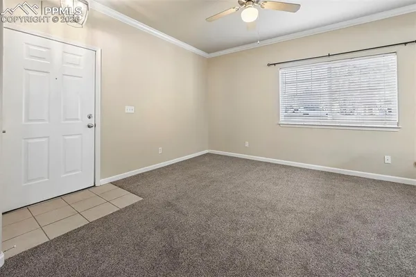 an empty room with windows and fan