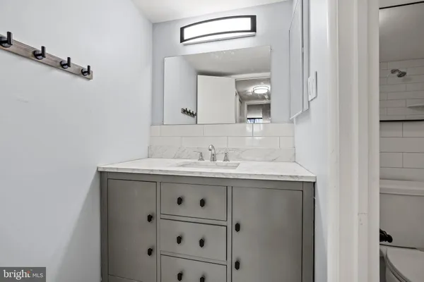 a bathroom with a granite countertop sink and a mirror