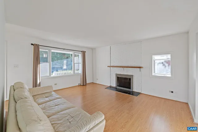 a view of empty room with wooden floor and fireplace