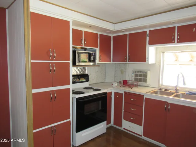 a kitchen with stainless steel appliances granite countertop a refrigerator a sink a stove and dishwasher with wooden cabinets