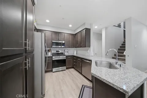 a modern kitchen with granite countertop stainless steel appliances and wooden cabinets