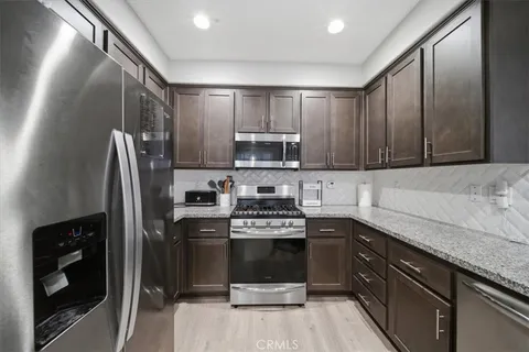 a kitchen with stainless steel appliances granite countertop a stove a sink and a refrigerator