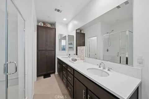 a bathroom with a sink double vanity granite tub shower and a mirror