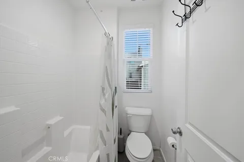 a white toilet sitting next to a bath tub