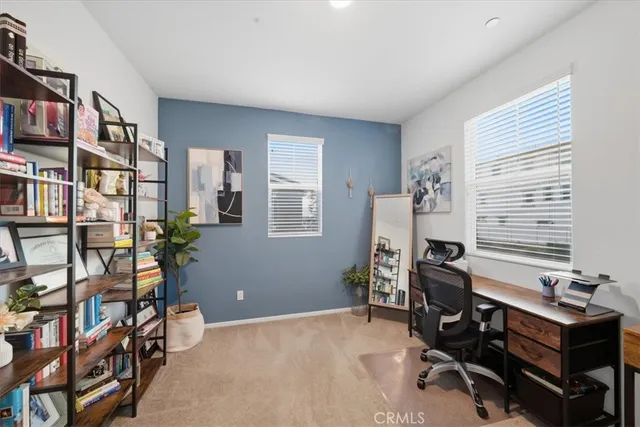 a view of a workspace with furniture and a window
