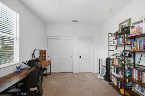 a view of a workspace with furniture and a bookshelf