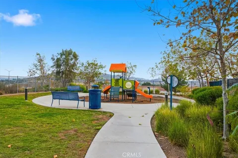 a view of a swimming pool with a bench and trees in the background