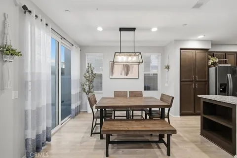 a kitchen with a table chairs refrigerator and microwave