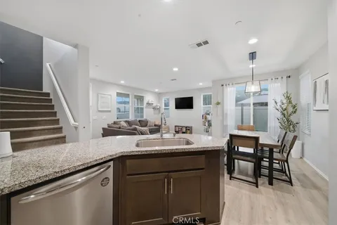 a kitchen with granite countertop sink table and chairs