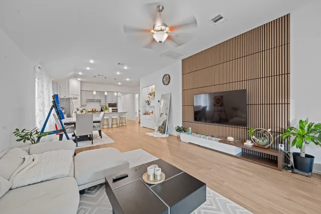 a view of a livingroom with a ceiling fan & wooden floor