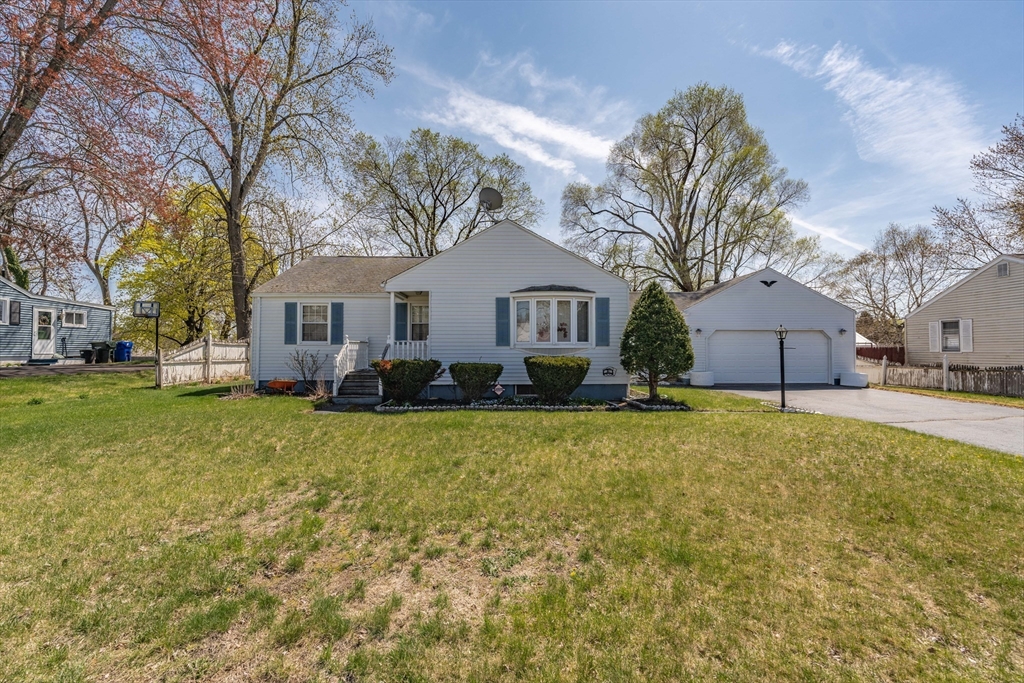 a front view of a house with a yard and trees