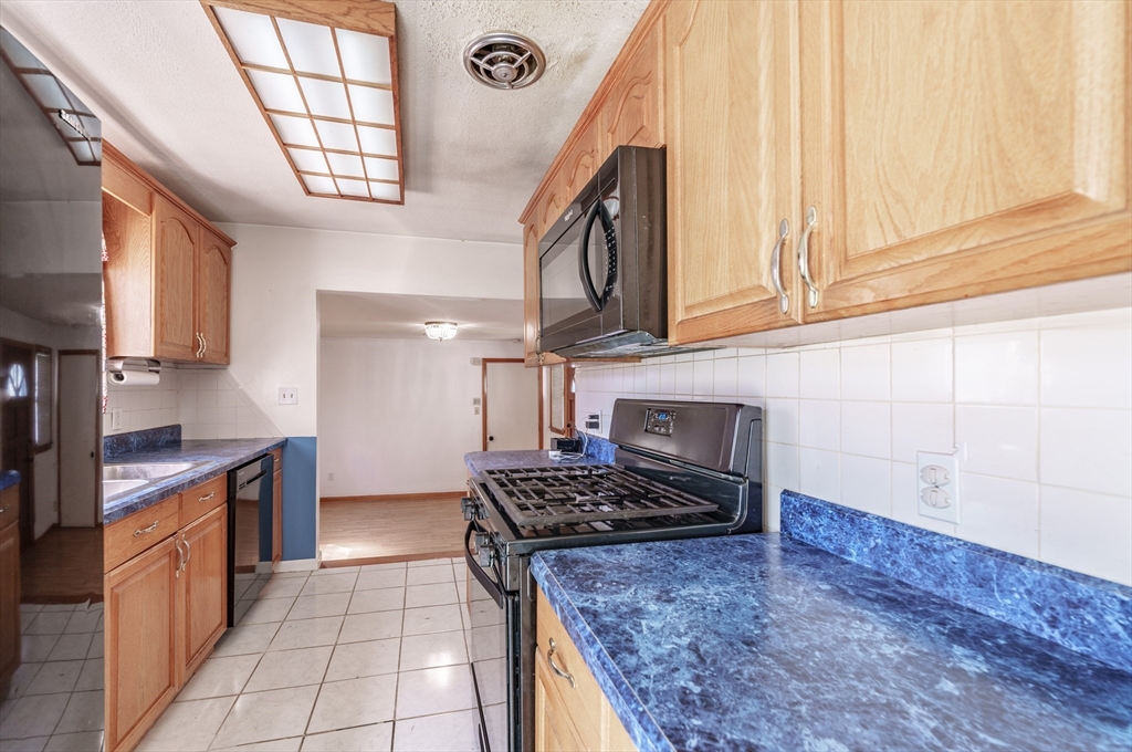 127 Cheyenne Road Springfield, MA 01109 - Photo 13 of 42 a kitchen with stainless steel appliances granite countertop a stove a sink and a microwave
