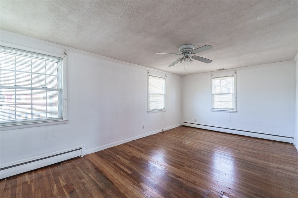 127 Cheyenne Road Springfield, MA 01109 - Photo 19 of 42 an empty room with wooden floor chandelier fan and windows