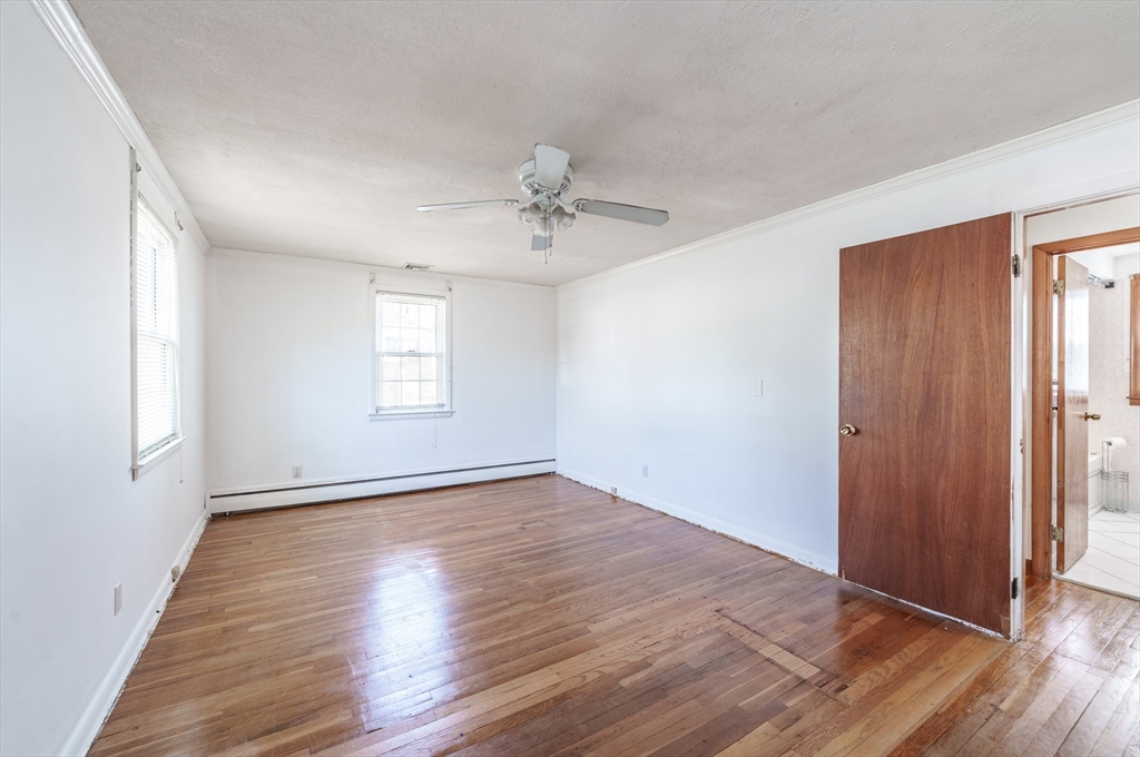 127 Cheyenne Road Springfield, MA 01109 - Photo 21 of 42 an empty room with wooden floor chandelier fan and windows