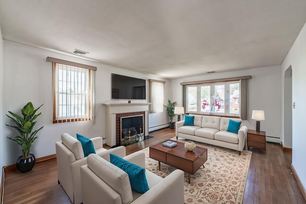 127 Cheyenne Road Springfield, MA 01109 - Photo 6 of 42 a living room with furniture flat screen tv and a fireplace